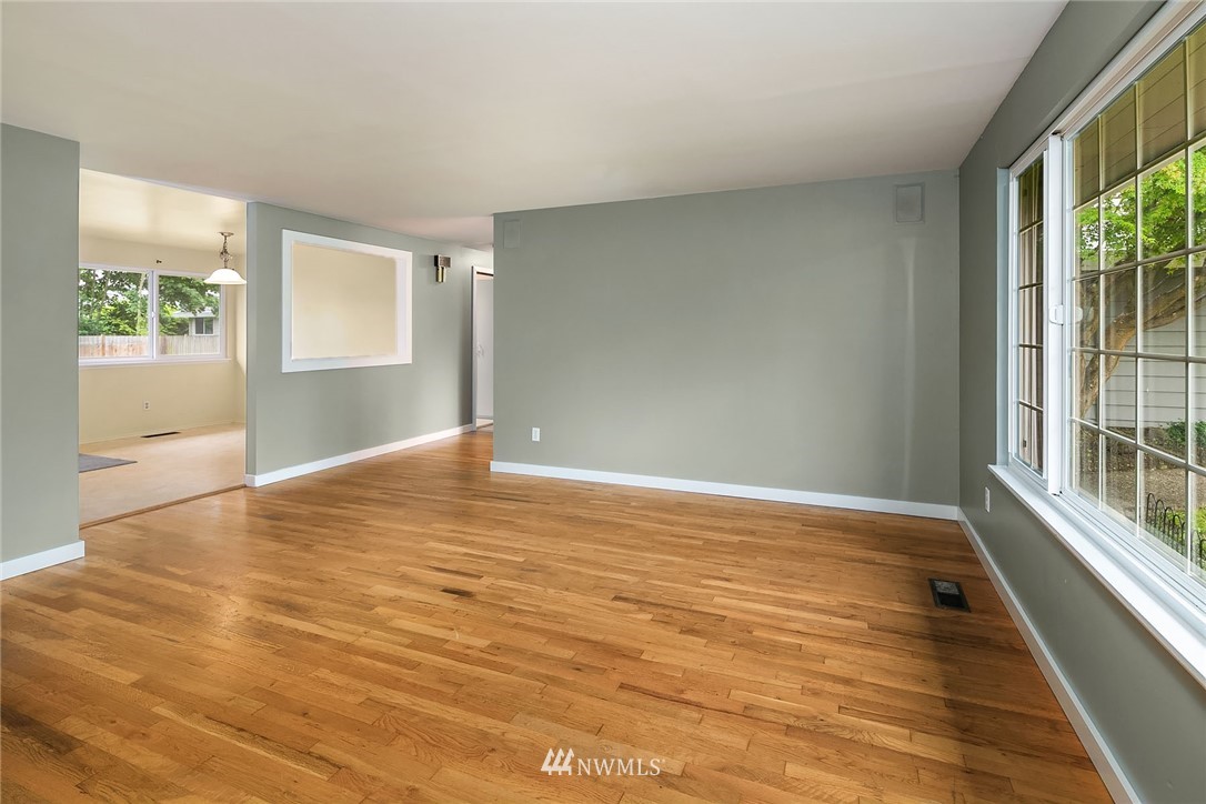 1110 Olympia Avenue Northeast Renton, WA 98056 - Photo 5 of 20 a view of an empty room with wooden floor and a window