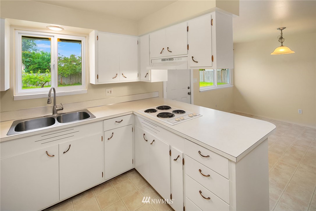 1110 Olympia Avenue Northeast Renton, WA 98056 - Photo 7 of 20 a kitchen with cabinets appliances a sink and a window