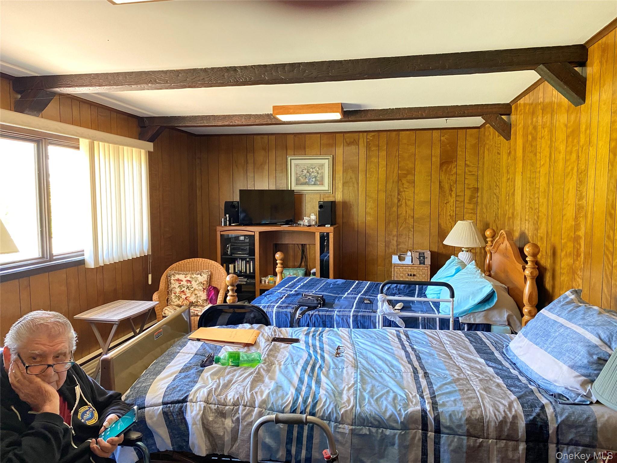 23 Colton Road Mahopac, NY 10541 - Photo 12 of 35 The Family room off the entry foyer features wood paneling, exposed ceiling beams, and a window with vertical blinds