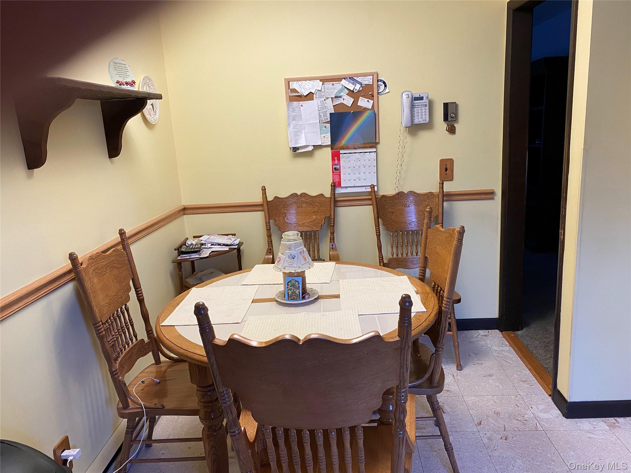 23 Colton Road Mahopac, NY 10541 - Photo 22 of 35 Dining area featuring light-colored walls with a wood trim, a light-colored tile floor, and a wooden wall shelf