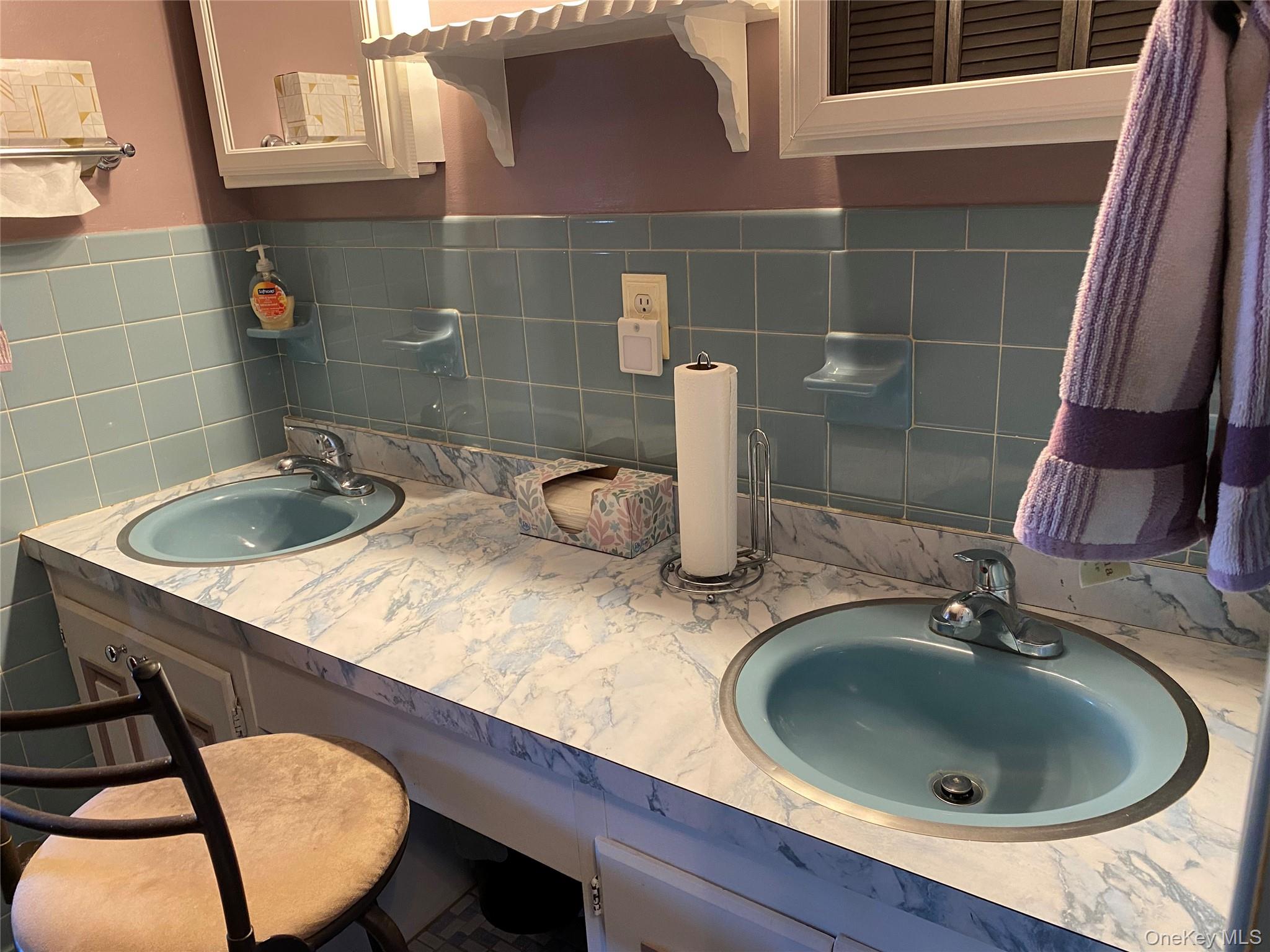 23 Colton Road Mahopac, NY 10541 - Photo 28 of 35 The bathroom features a double vanity with two blue sinks, a patterned countertop, and light blue wall tiling