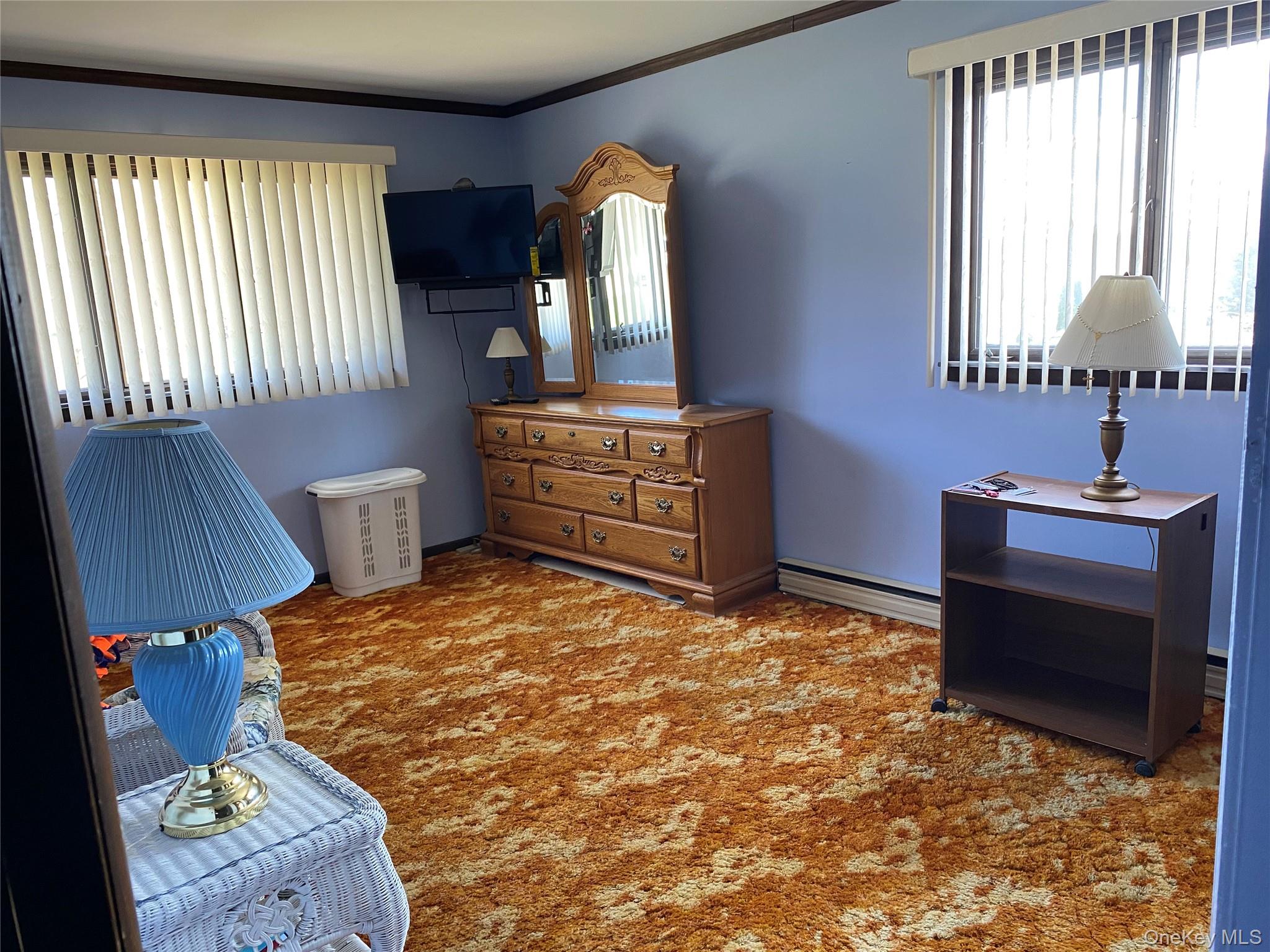 23 Colton Road Mahopac, NY 10541 - Photo 30 of 35 This room features two windows with vertical blinds, providing natural light, and a textured carpeted floor