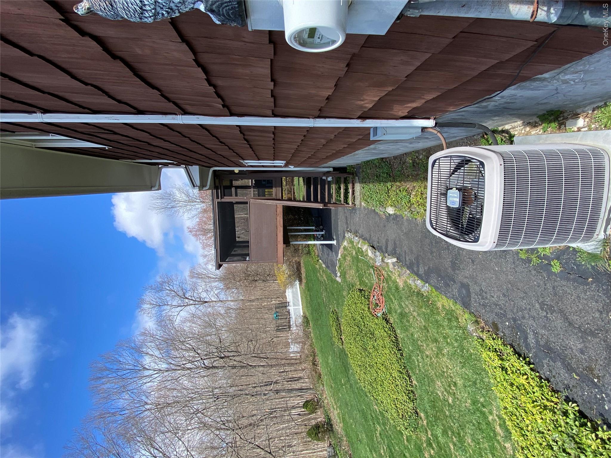 23 Colton Road Mahopac, NY 10541 - Photo 7 of 35 The property features wood shingle siding and a screened-in porch with a staircase