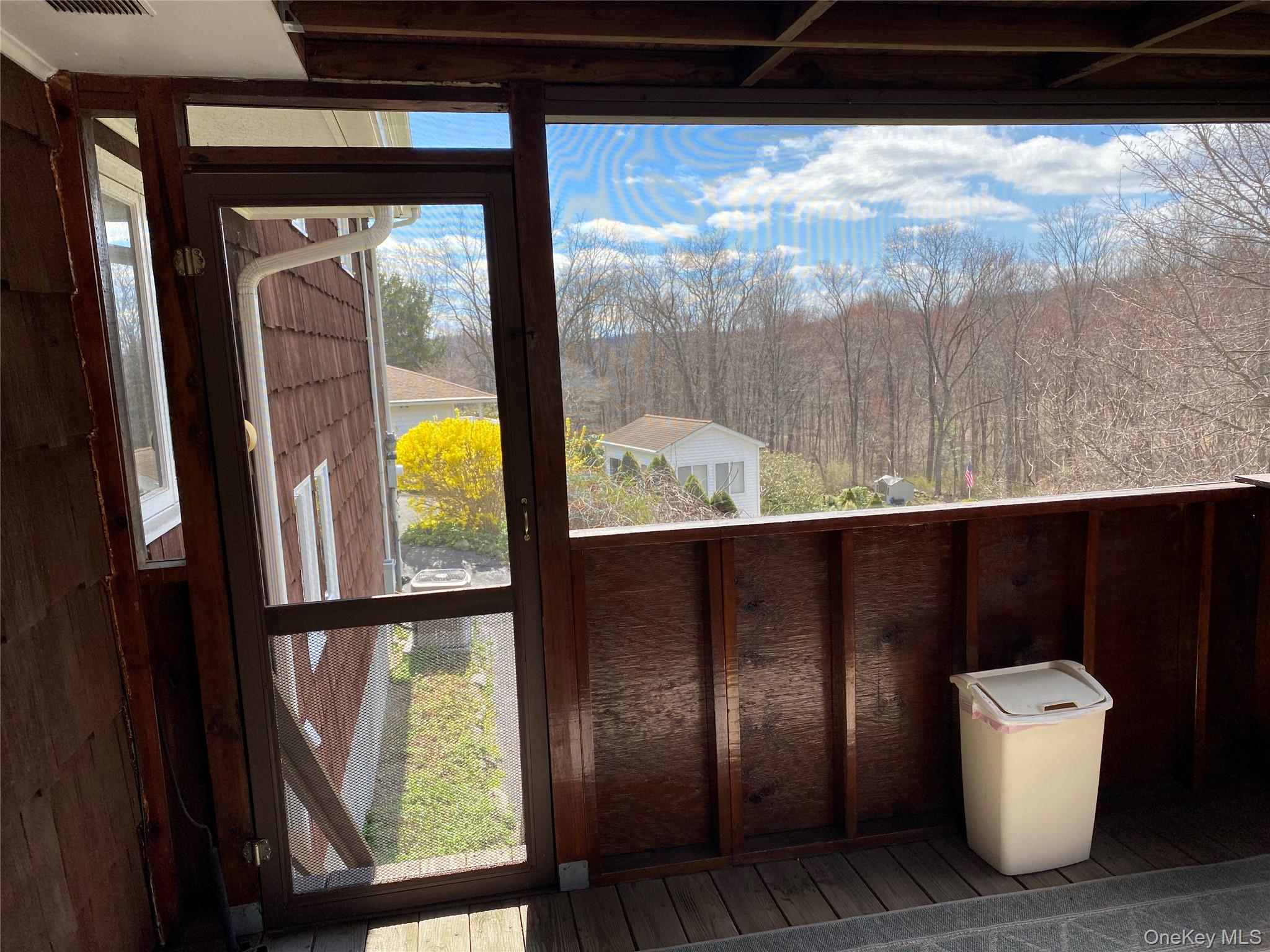 23 Colton Road Mahopac, NY 10541 - Photo 9 of 35 The property features a screened-in porch with views of the surrounding natural landscape