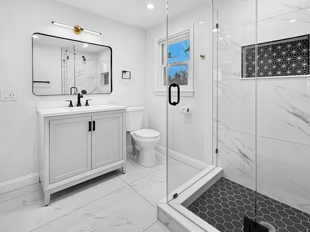 a bathroom with a shower a sink and a mirror