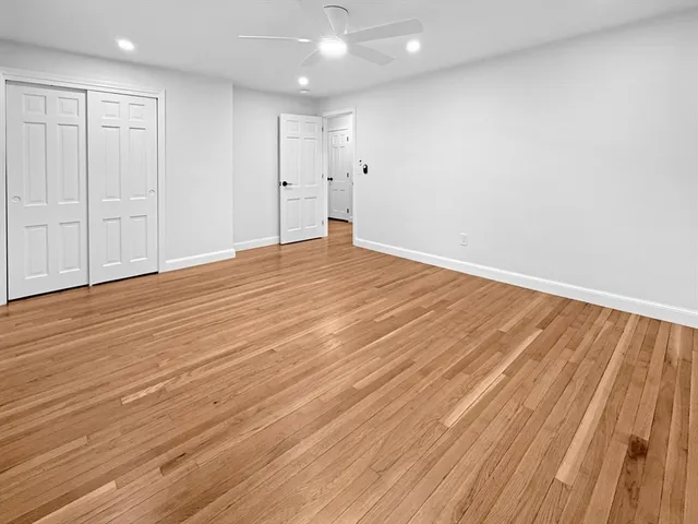 a view of an empty room with wooden floor