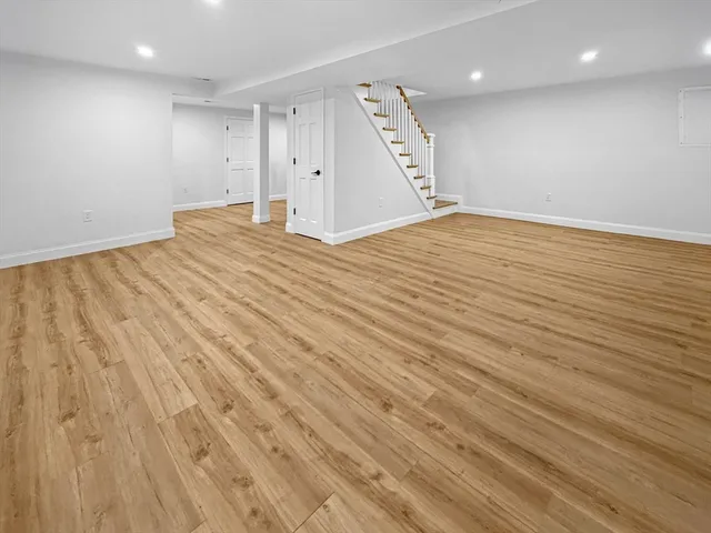 an empty room with wooden floor and a ceiling fan