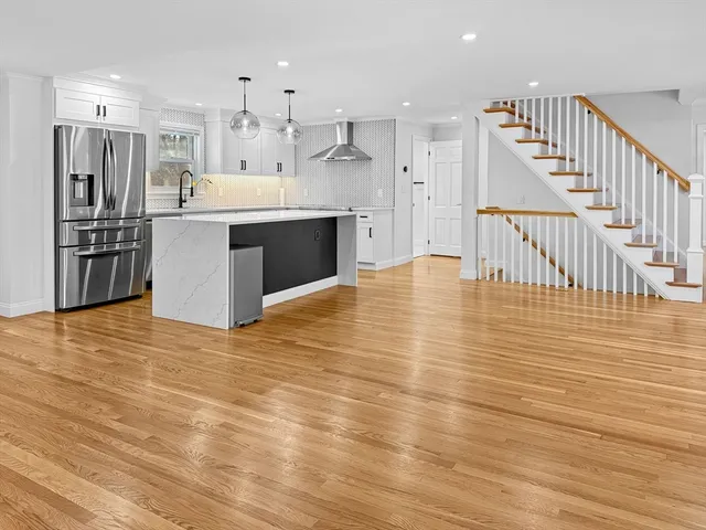 a large kitchen with stainless steel appliances kitchen island granite countertop a large cabinets a sink and a stove