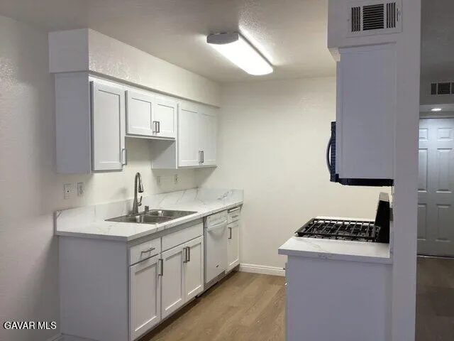 a kitchen with sink stove and cabinets