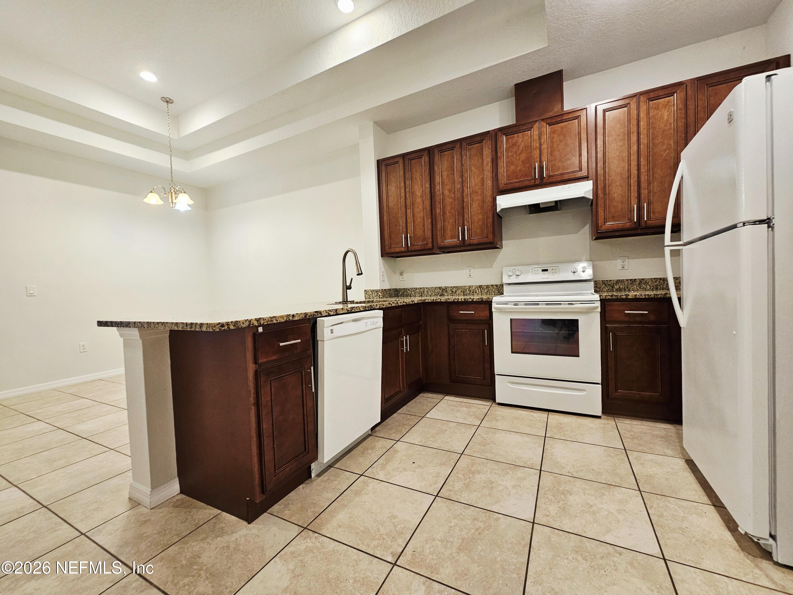 44 Prosperity Lane, Unit A Palm Coast, FL 32164 - Photo 3 of 9 a kitchen with stainless steel appliances granite countertop a stove a sink and a refrigerator