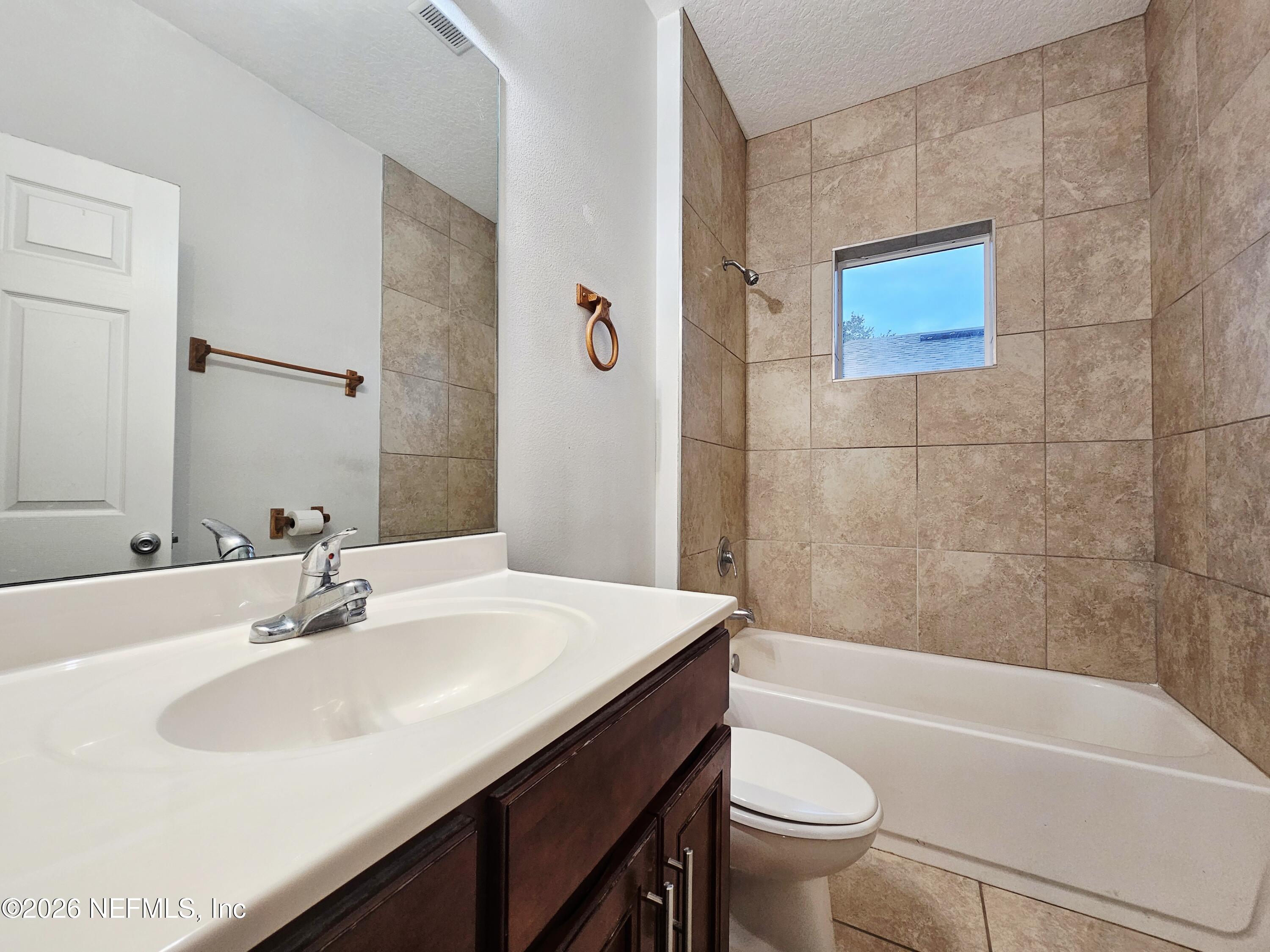 44 Prosperity Lane, Unit A Palm Coast, FL 32164 - Photo 8 of 9 a bathroom with a sink a toilet and a bathtub