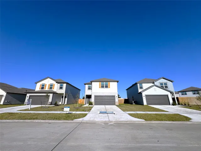 a front view of a house with a yard and car parked