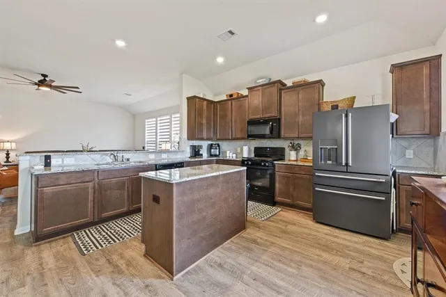 a kitchen with stainless steel appliances granite countertop a sink stove and refrigerator
