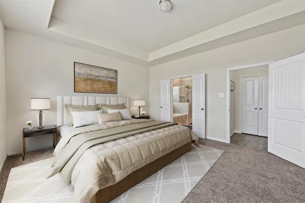 a spacious bedroom with a bed and a lamp