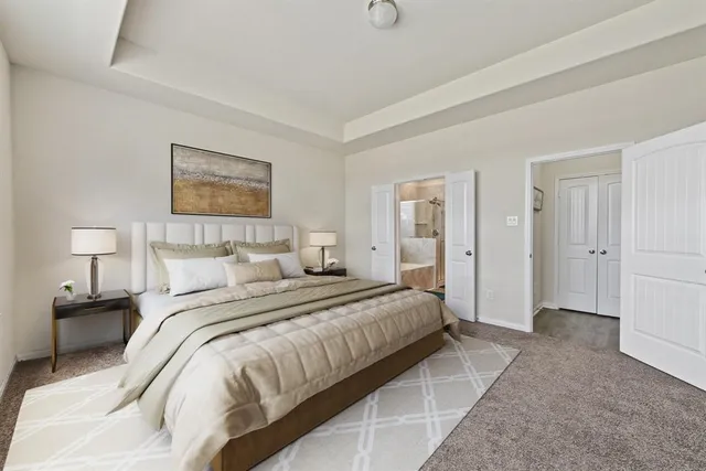 a spacious bedroom with a bed and a lamp