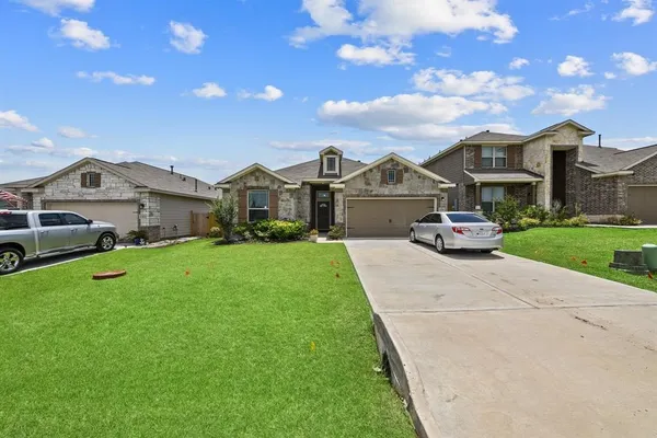 a front view of a house with a garden and yard
