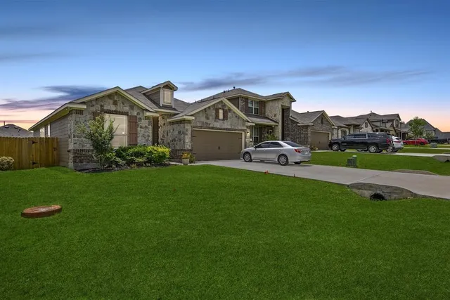 a front view of a house with a garden and yard