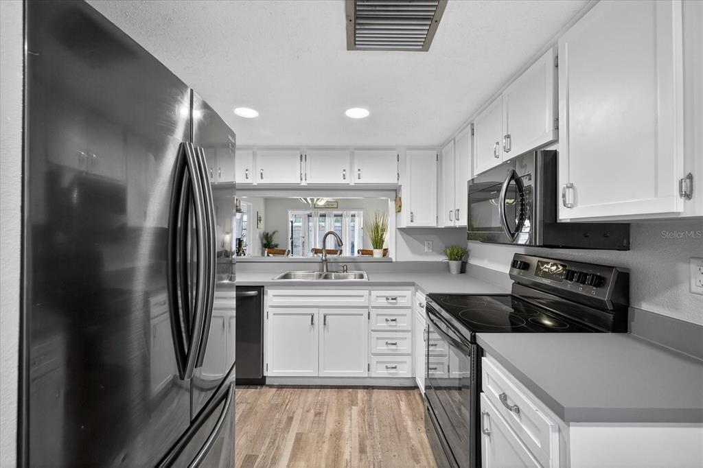 3230 Teeside Drive New Port Richey, FL 34655 - Photo 7 of 32 a kitchen with stainless steel appliances granite countertop a sink stove and refrigerator