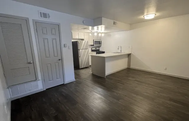 a view of a kitchen with wooden floor and electronic appliances