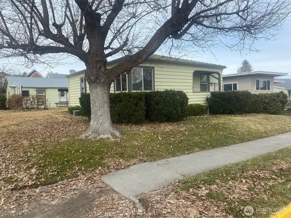 a front view of a house with a yard and trees