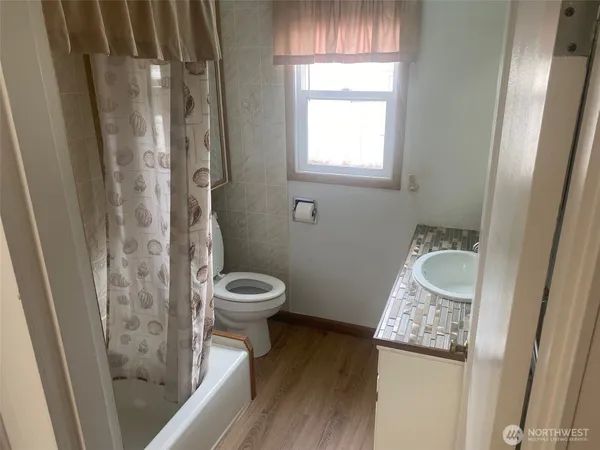a bathroom with a granite countertop sink and a toilet
