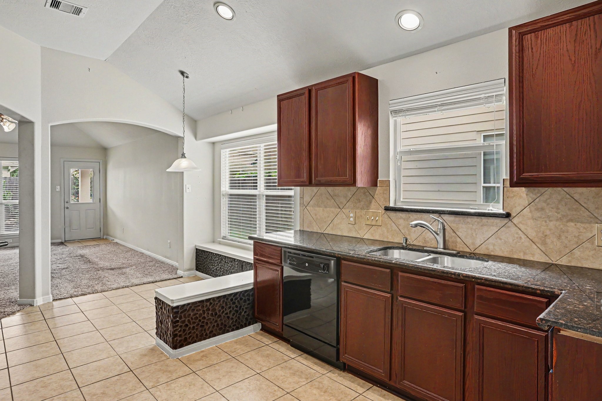 25222 Ginger Ranch Drive Katy, TX 77494 - Photo 6 of 33 Plenty of natural light in the kitchen and breakfast nook. It features a double sink, built-in dishwasher, and tiled flooring.