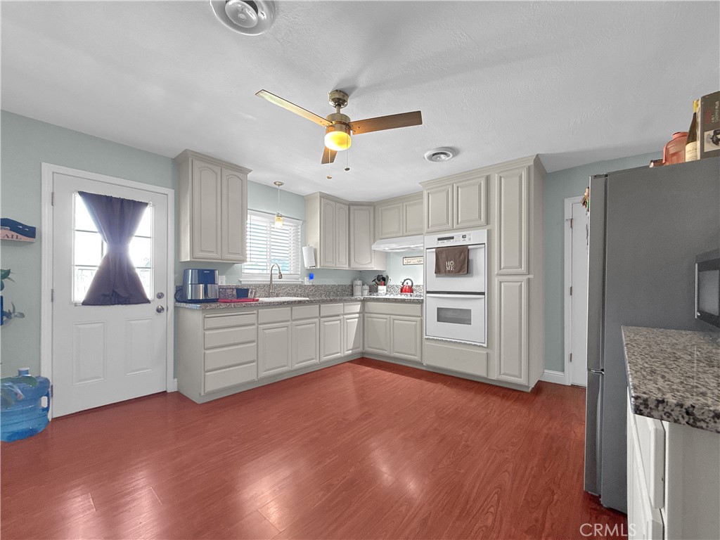 6800 Helton Street Winton, CA 95388 - Photo 14 of 22 a kitchen with granite countertop a refrigerator and a stove top oven