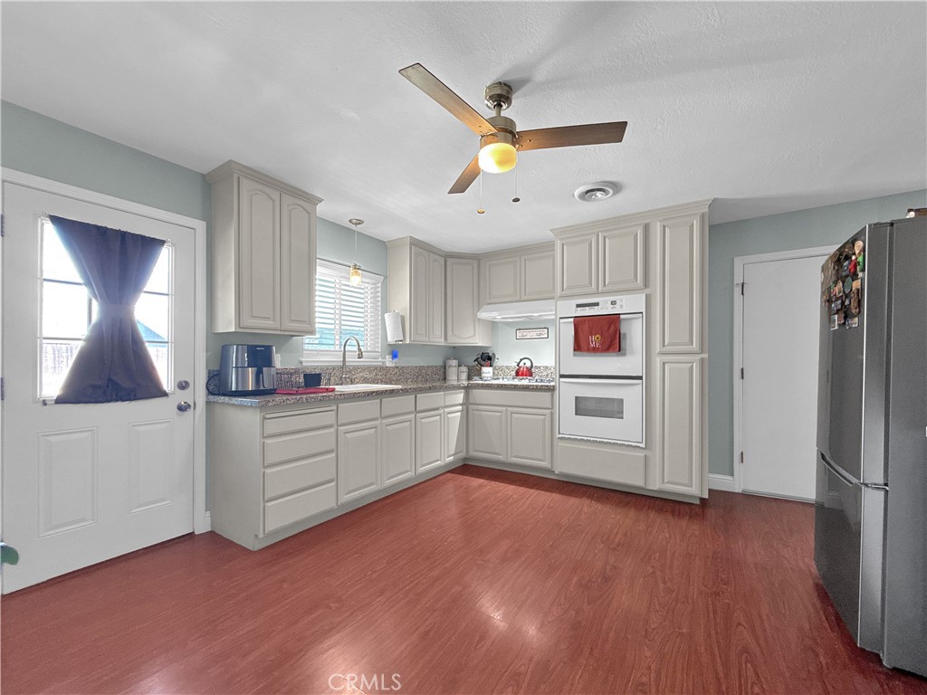 6800 Helton Street Winton, CA 95388 - Photo 20 of 22 a kitchen with a refrigerator cabinets and wooden floor