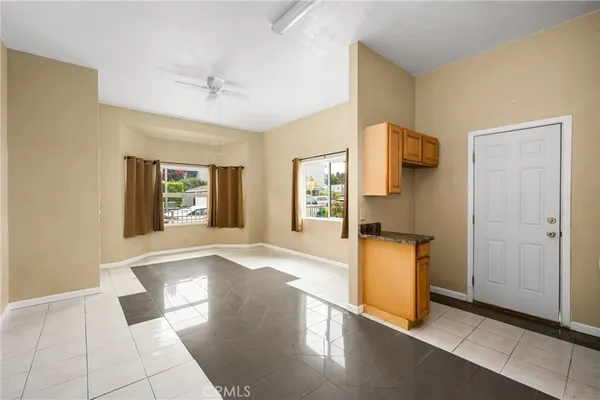 a living room with stainless steel appliances kitchen island granite countertop a refrigerator and a sink