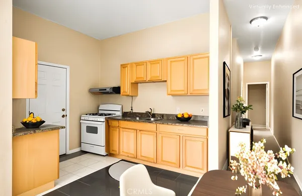 a kitchen with granite countertop a sink stove and refrigerator