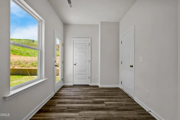 a view of a room with wooden floor and windows