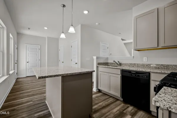 a kitchen with granite countertop a sink a stove and cabinets
