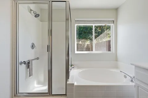a white bath tub sitting next to a shower