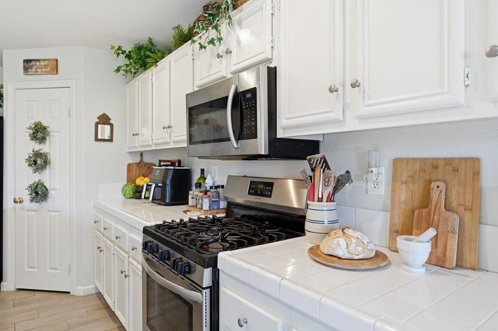 618 Jacks Creek Road Escondido, CA 92027 - Photo 8 of 48 a kitchen with white cabinets and appliances