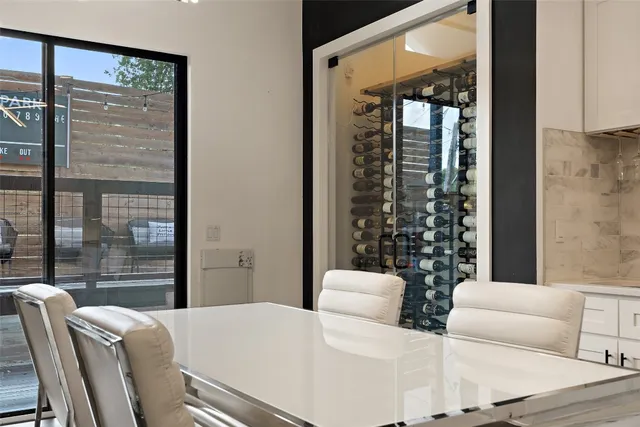 a large white kitchen with a large island oven a stove dining table and chairs