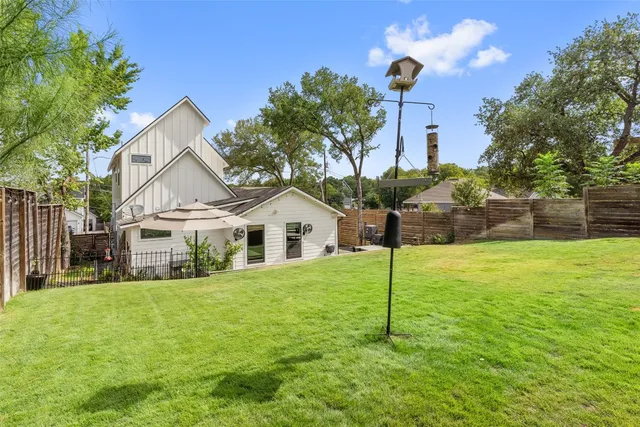 a view of a house with swimming pool and a yard