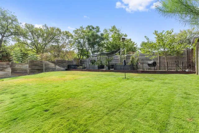 a view of a house with a yard and potted plants