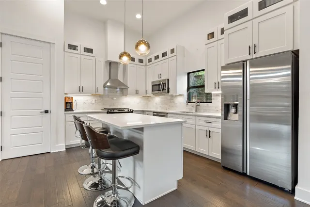 a kitchen with kitchen island granite countertop a sink cabinets and stainless steel appliances
