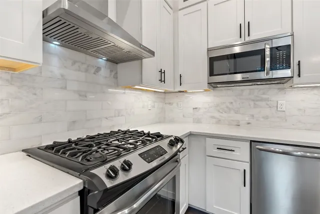 a kitchen with stainless steel appliances a sink a stove and cabinets