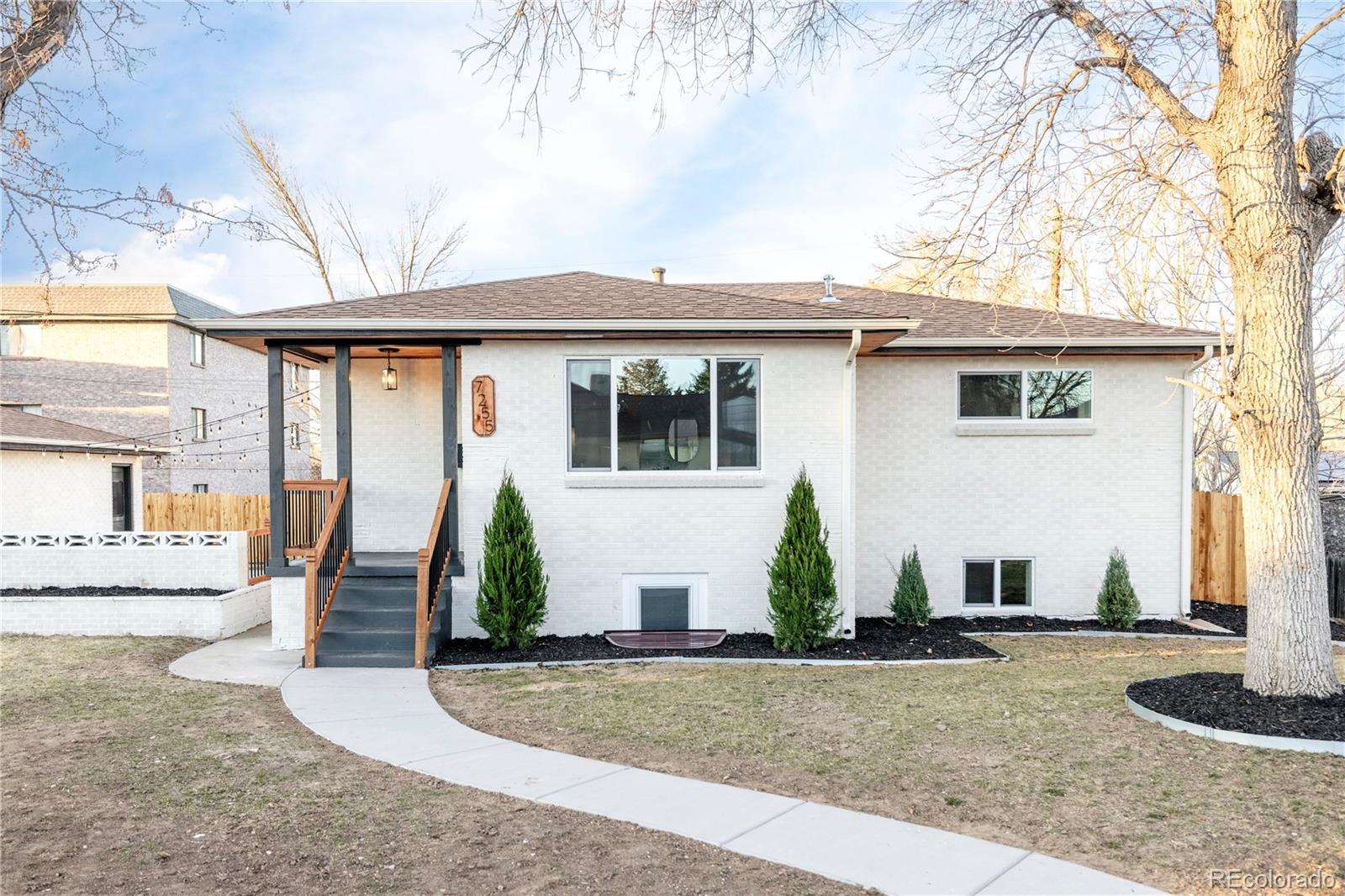 7255 West 35th Place Wheat Ridge, CO 80033 - Photo 1 of 30 a front view of a house with garden