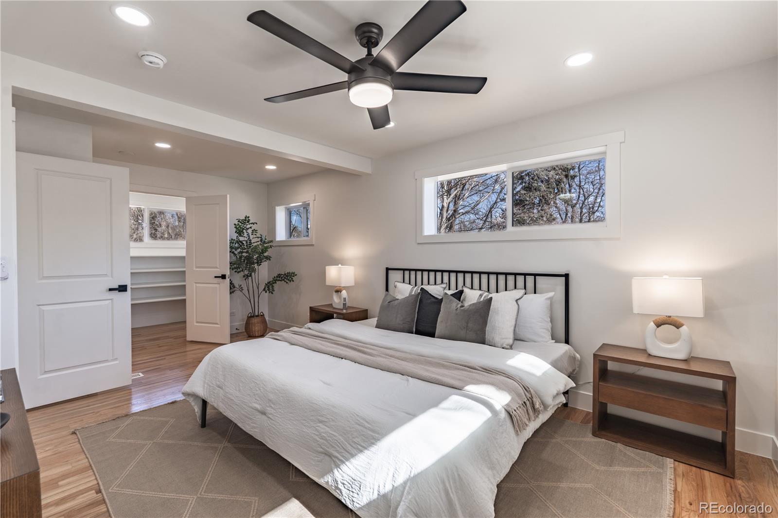 7255 West 35th Place Wheat Ridge, CO 80033 - Photo 16 of 30 a bedroom with a large bed and a chandelier