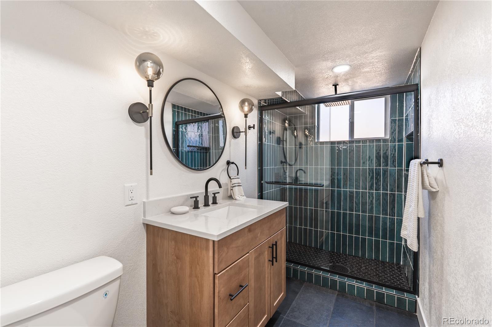 7255 West 35th Place Wheat Ridge, CO 80033 - Photo 27 of 30 a bathroom with a sink mirror toilet and shower