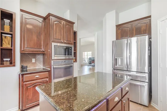 a kitchen with stainless steel appliances granite countertop a refrigerator and a stove