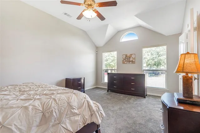 a bedroom with a bed and a flat tv screen on dresser