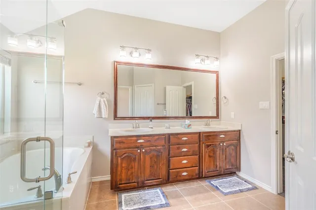 a bathroom with a granite countertop sink a mirror and a shower