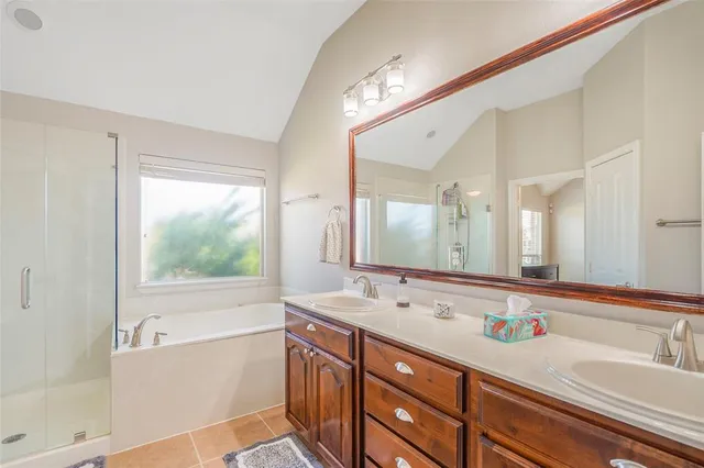 a bathroom with a tub a sink and a large mirror