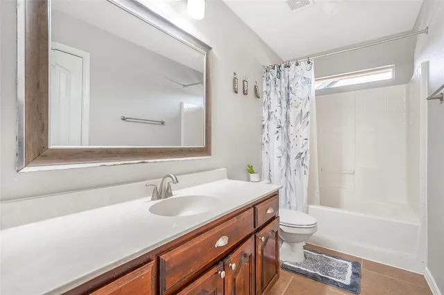 a bathroom with a sink a toilet a mirror and shower