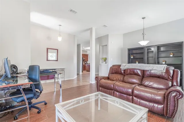 a living room with furniture a flat screen tv and kitchen view