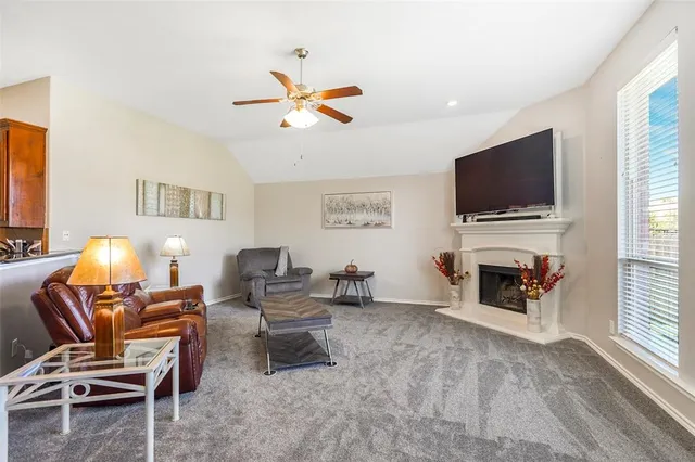 a living room with furniture a fireplace and a flat screen tv