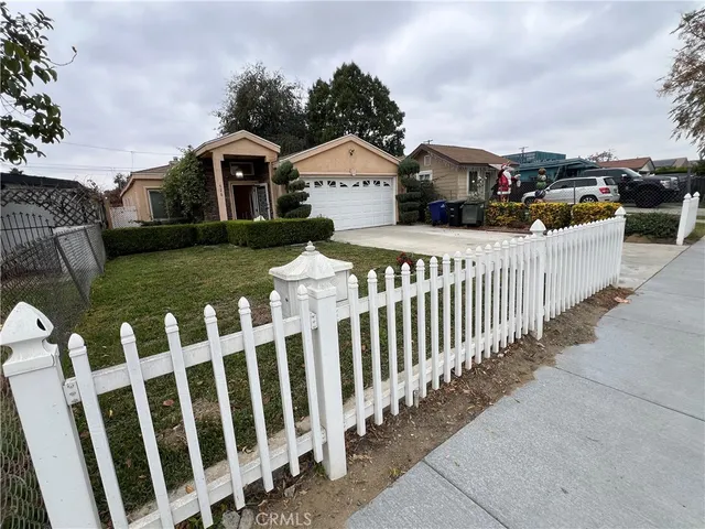 a view of a white house with wooden fence